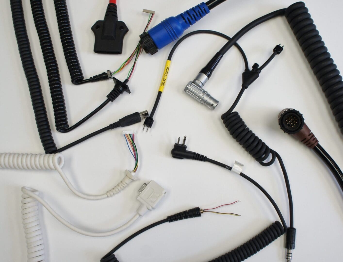 A variety of wires and cables, showcasing their cable capabilities, are laid out on a white surface.
