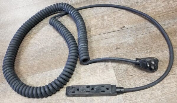 A black Coiled Power Supply Cord with Molded Plugs on a wooden floor.