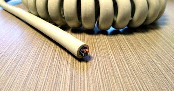 A white coiled cable on top of a table.