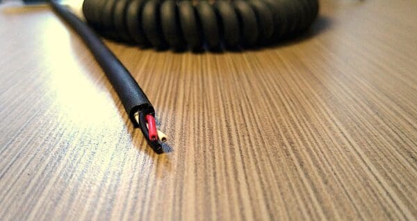 EC283 - Electronic Coiled Cord 28 Gauge with 3 Conductors - No Shield on a wooden table.