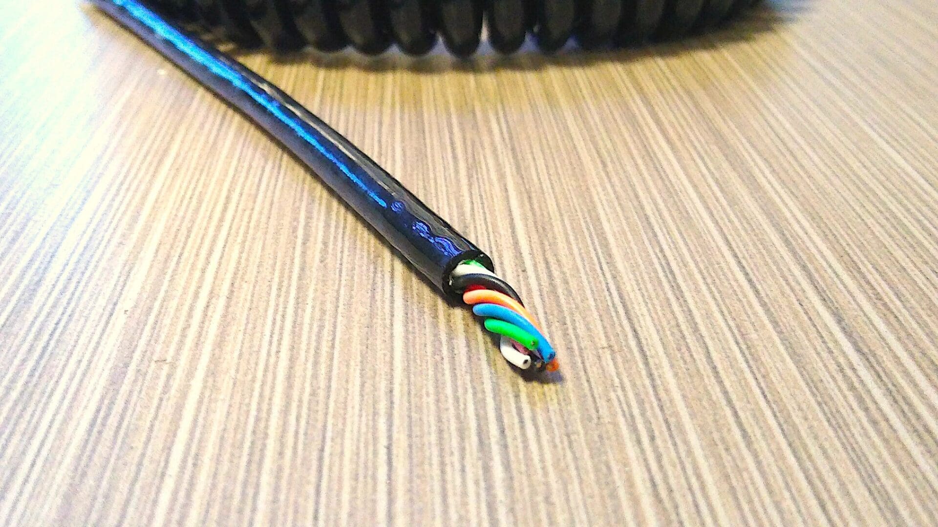 A black cable laying on top of a table.