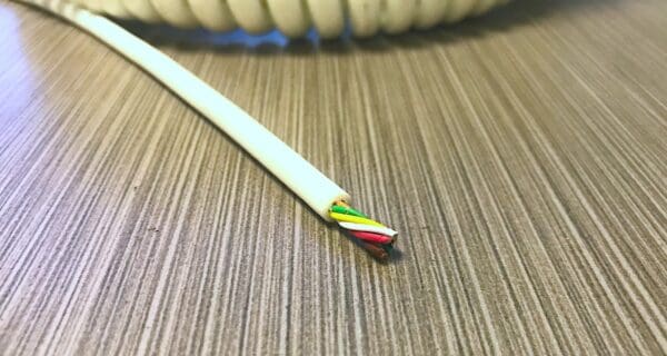 A white coiled cable on top of a table.