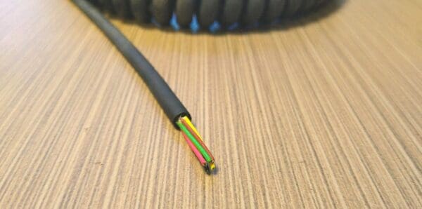EC286 - Electronic Coiled Cord 28 Gauge with 6 Conductors - No Shield on a wooden table.