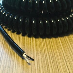 A black coiled cable on a table.