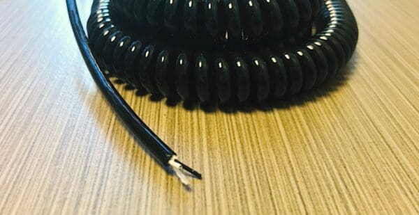 A black coiled cable on a table.