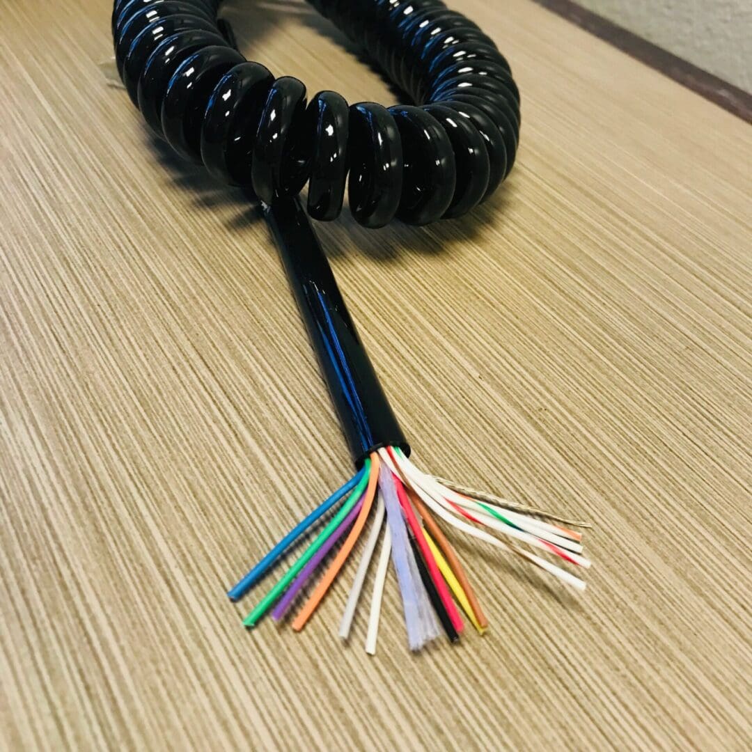 A black coiled cable on a table.