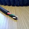 A red, black, and white cable on top of a table.