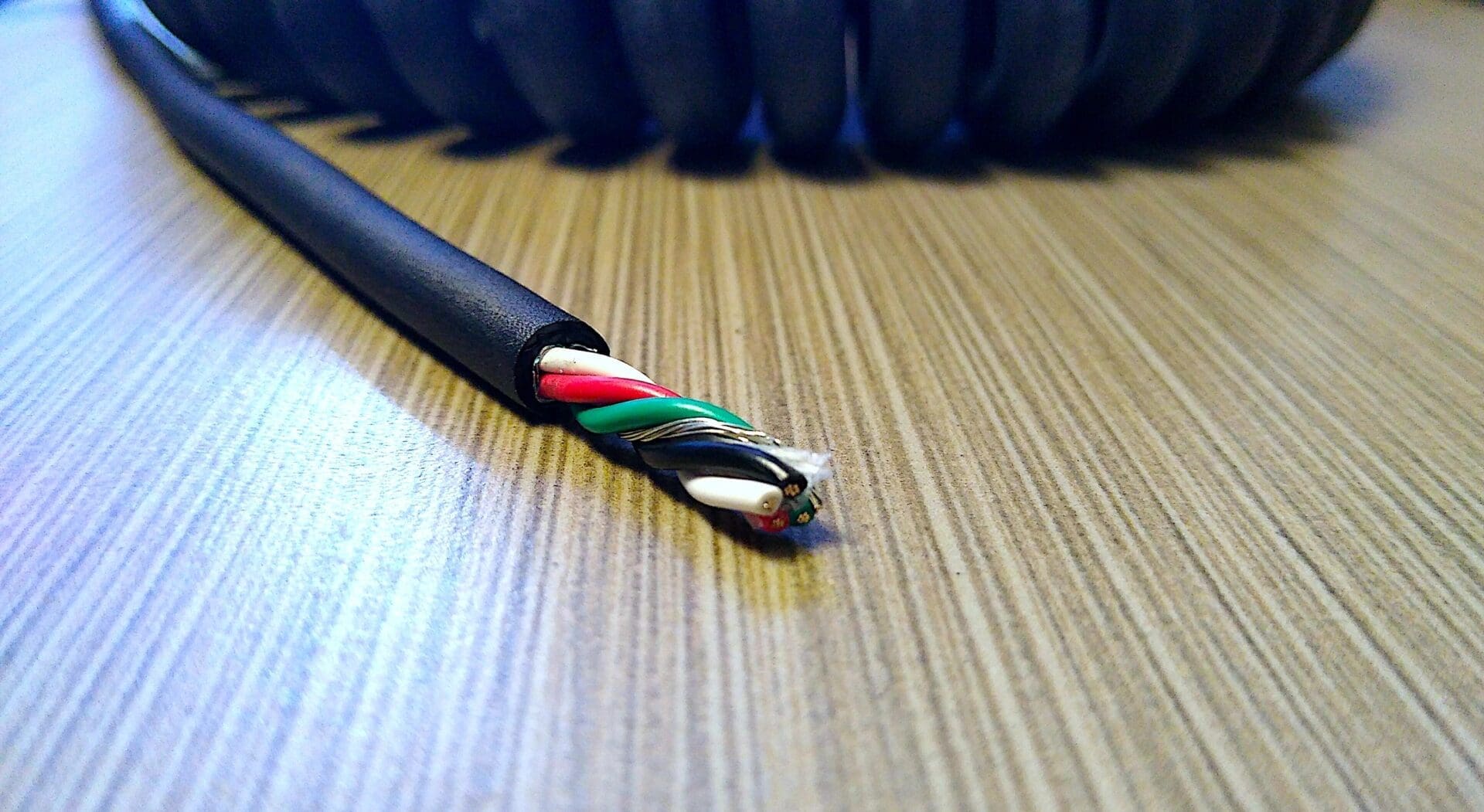A red, black, and white cable on top of a table.