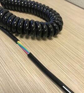 A black coiled cord on a table.