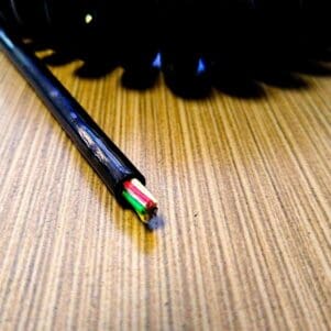 ECS245 - Electronic Coiled Cord 24 Gauge with 5 Conductors - Aluminum Shielded on a wooden table.
