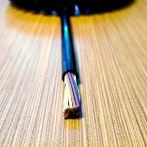 A ECS2618 - Electronic Coiled Cord 26 Gauge with 18 Conductors - Aluminum Shielded on a wooden table.