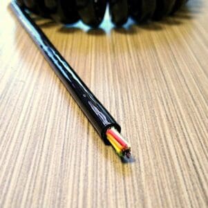 A black and yellow ECS2810 - Electronic Coiled Cord 28 Gauge with 10 Conductors - Aluminum Shielded on a wooden table.