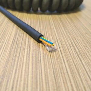 A black cable is sitting on top of a wooden table.