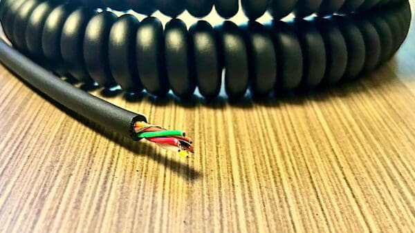 A black coiled cable on top of a table.