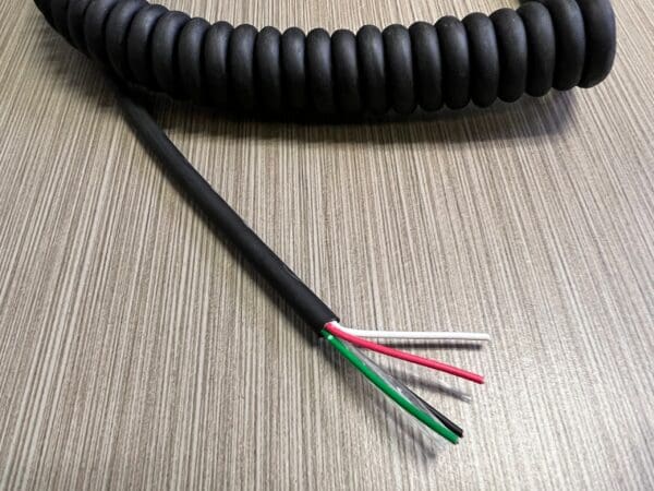 A black coiled cable on a table.