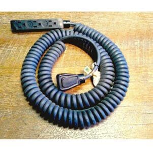 A Coiled Power Supply Cord with Molded Plugs on a wooden table.