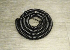 A 6.5 Ft. Length - NCC4PR24A SCI-FLEX COILED CAT5e 4 ETHERNET 24GA PAIRS W/ RJ45 PLUGS - ONLINE DEAL! on a tile floor.