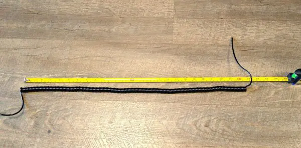 EC282 - Electronic Coiled Cord 28 Gauge with 2 Conductors - No Shield - ONLINE DEAL! and a ruler on a wooden floor.