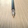 CS-195 - Low Loss Flexible, Outdoor Rated Coax Cable Double Shielded w/ Black PE Jacket is sitting on top of a wooden table.