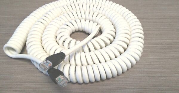 A white coiled telephone cord on a table.