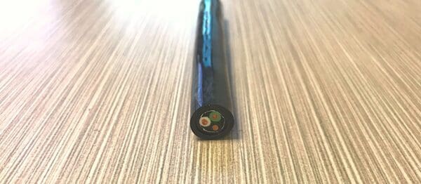 A black plastic tube on top of a wooden table.