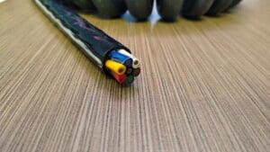 A wire is laying on top of a wooden table.