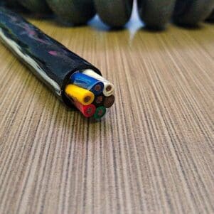 A wire is laying on top of a wooden table.