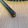 A black wire laying on top of a wooden table.