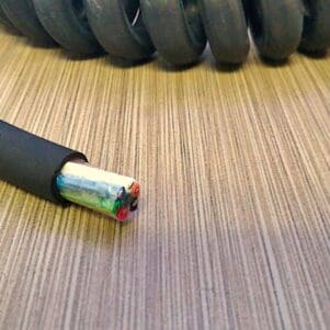A black coiled cable on top of a table.