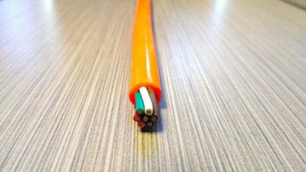 A PCE167 16 GA 7 COND. 300V COIL CABLE MAX DUTY is sitting on top of a table.