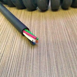 A black and white cable laying on top of a wooden table.