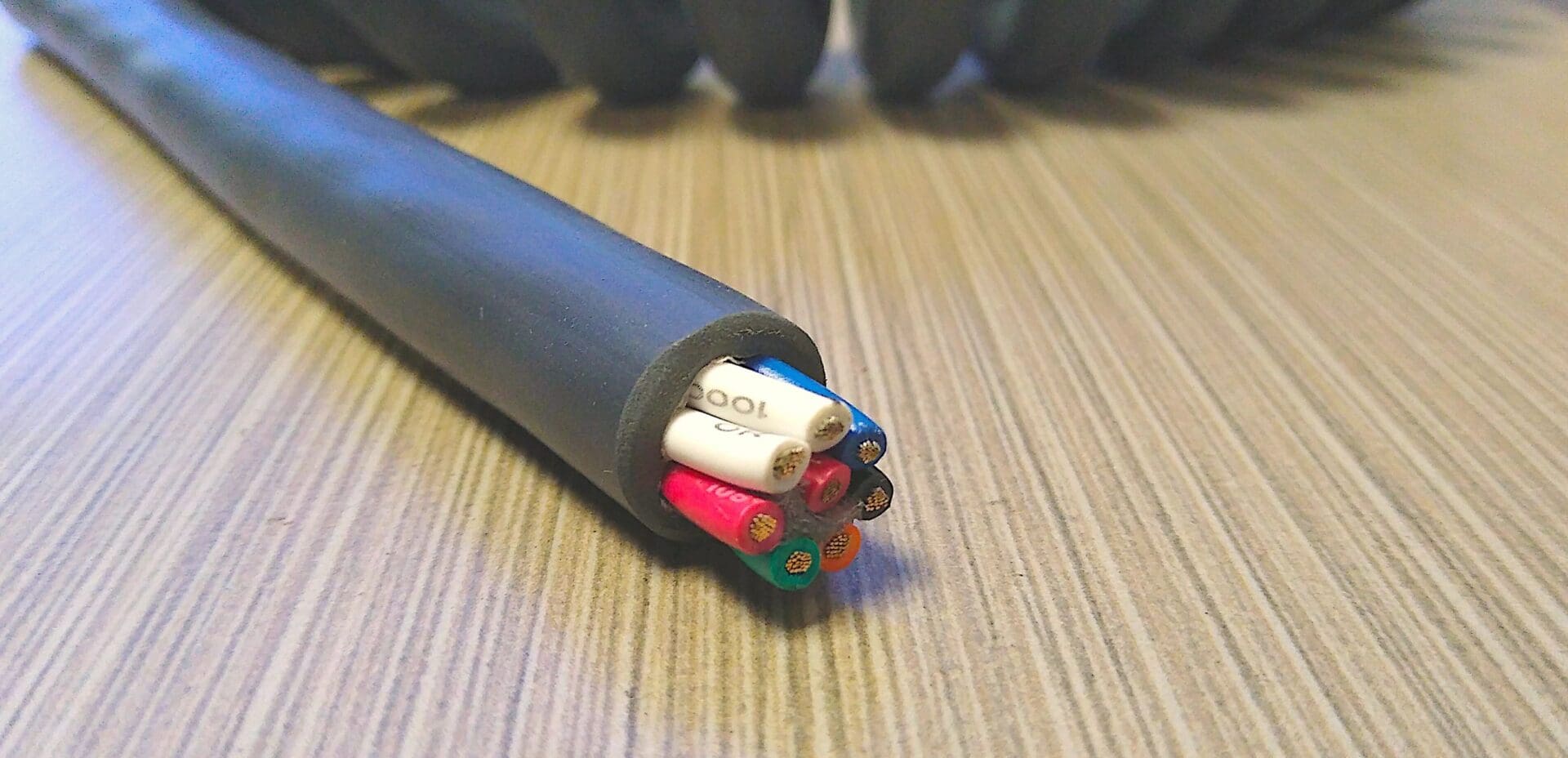 A PCO168 - Power Coiled Cord 16 Gauge with 8 Conductors - Non-Shielded - 600 Volts cable with different colored wires on it.