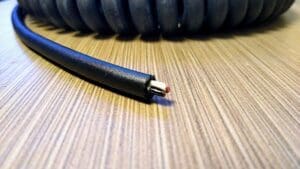 A black coiled cable on top of a table.