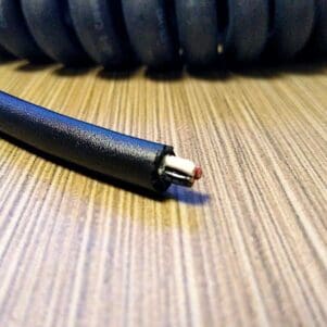 Cut coiled telephone cord with exposed red wire