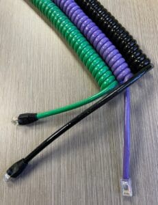 Colorful coiled cables on a textured surface.