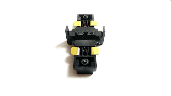 A small black and yellow Juno R23 Miniature Straight Connector (R-Type Tracks) construction toy truck viewed from above on a white background.